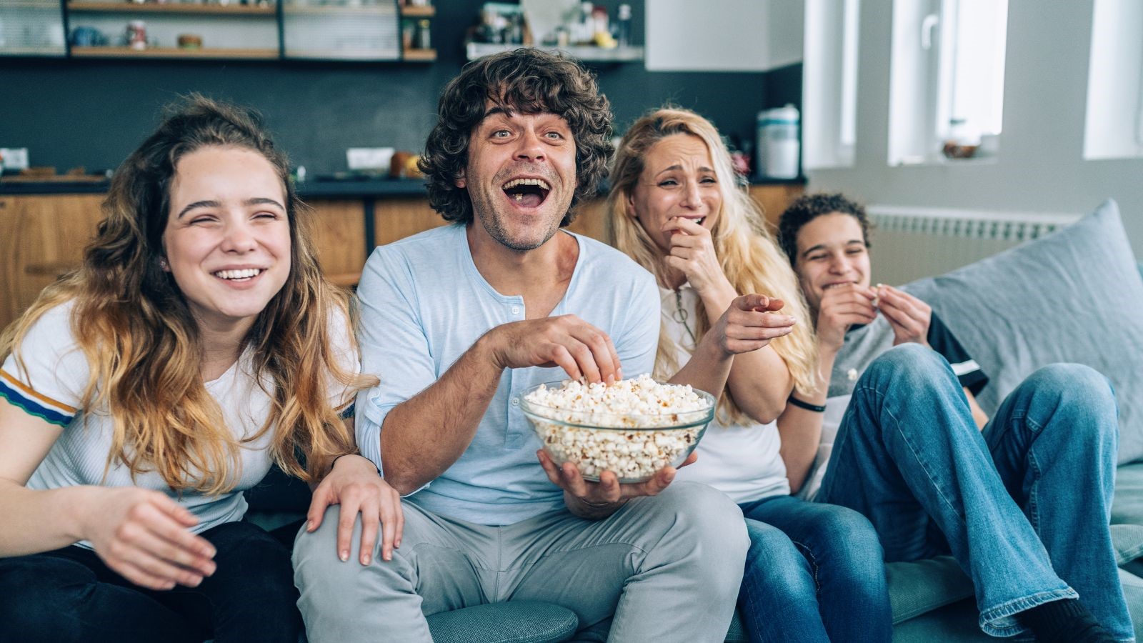 Familia mirando peli en el sofá.