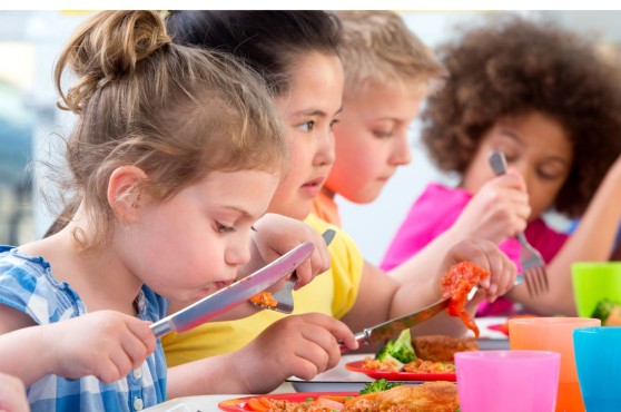 Niños y niñas comiendo.